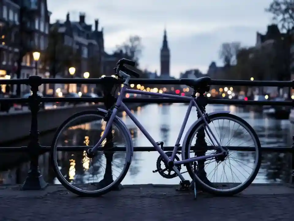 A bicycle leaning on a railing beside a canal at dusk