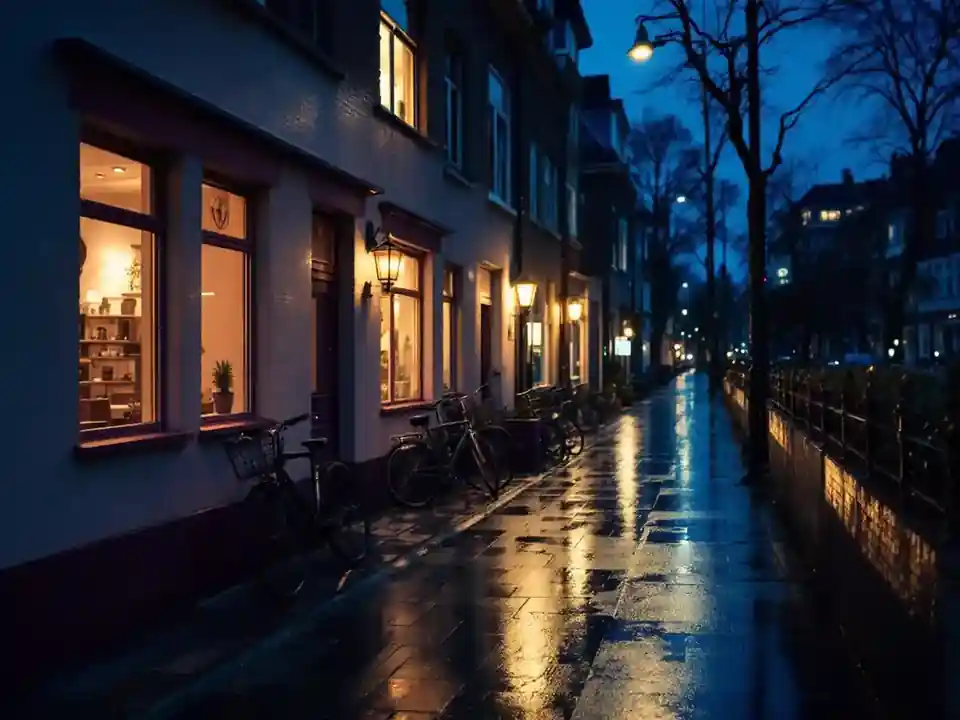 A quiet city street at dusk with wet pavement and lit windows