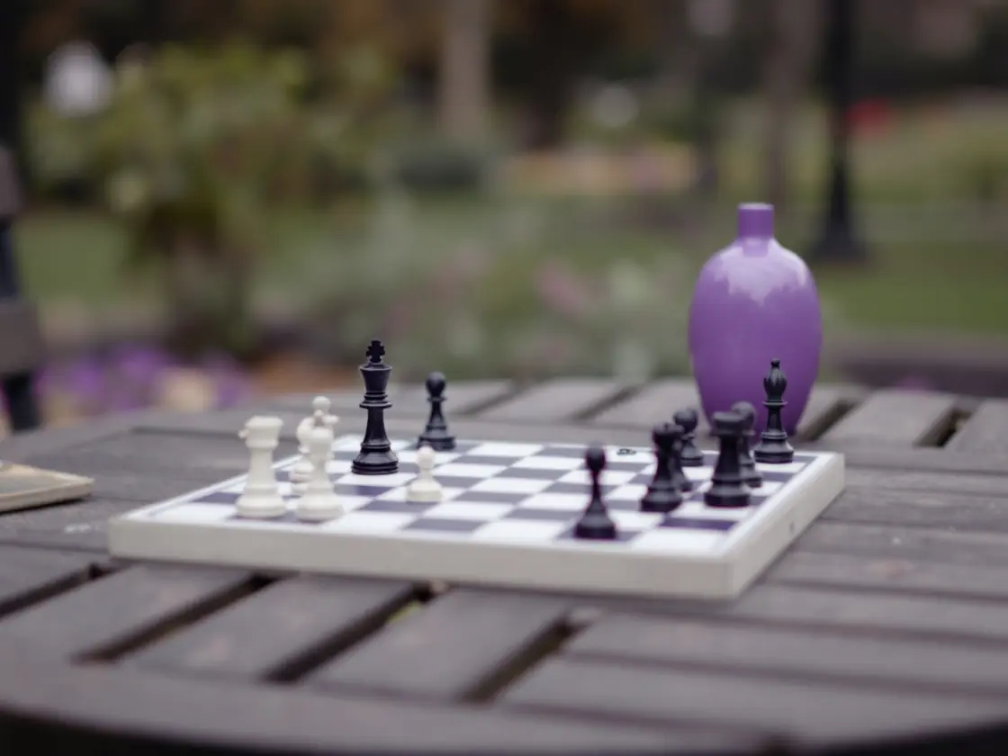 A chess game in progress on a park table